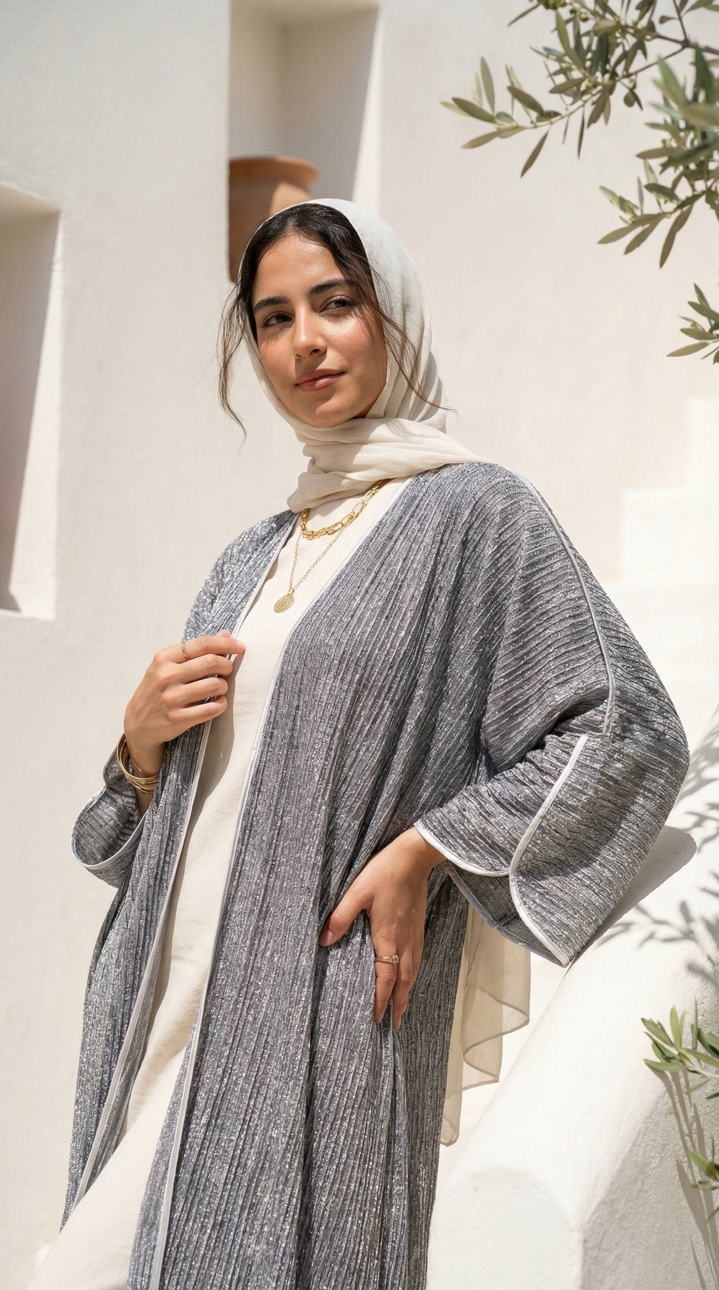 عباية بليسيه من قماش لوركس لامع مع أكمام واسعة وتفاصيل ناعمة على الحواف.